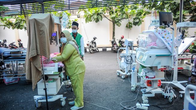 Seorang perawat memindahkan bayi yang baru lahir ke parkiran kendaraan di RSUD Sayang, Kabupaten Cianjur, Jawa Barat, Rabu (23/11/2022). [ANTARA FOTO/Raisan Al Farisi/foc].