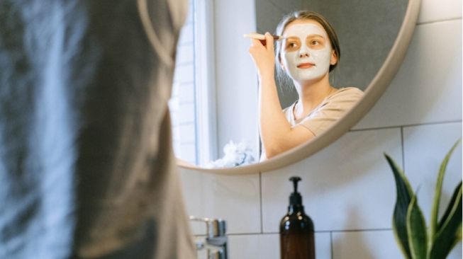 Ilustrasi perempuan melakukan perawatan wajah di rumah (Pexels/Ivan Samkov)