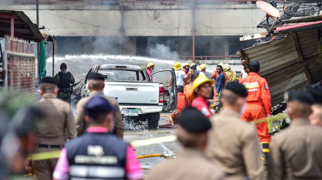 Petugas kepolisian dan petugas penyelamat memeriksa kerusakan setelah bom mobil meledak di kota Narathiwat, Thailand, Selasa (22/11/2022). [Madaree TOHLALA / AFP]
