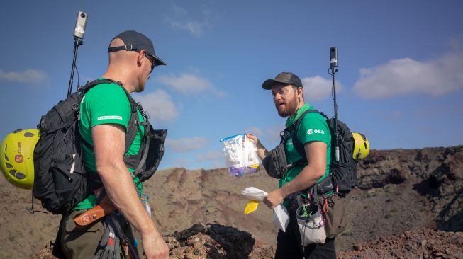 Para astronot dan ahli geologi Badan Antariksa Eropa mengumpulkan sampel di puncak gunung berapi purba selama program pelatihan untuk mempelajari cara menjelajahi Bulan dan Mars di Taman Nasional Timanfaya Pulau Lanzarote, Kepulauan Canary, Spanyol, Selasa (10/11/2022). [DESIREE MARTIN / AFP]