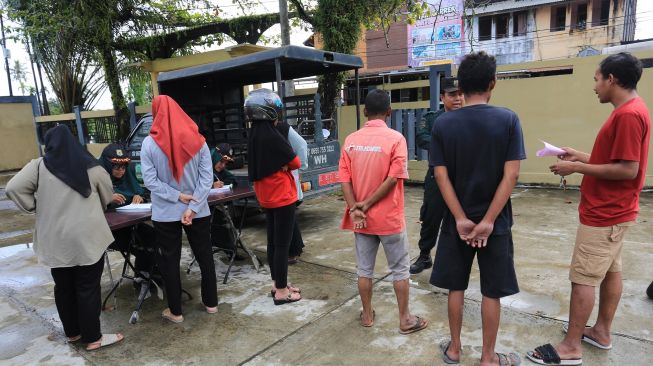 Polisi Syariah Islam atau Wilayatul Hisbah menegur dan mendata warga yang terjaring razia busana muslim di Desa Drien Rampak, Johan Pahlawan, Aceh Barat, Aceh, Kamis (24/11/2022). [ANTARA FOTO/Syifa Yulinnas/rwa].