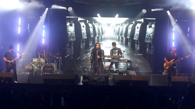 Penyanyi Marcello Tahitoe (tengah) bersama personel Dewa 19 beraksi saat konser di Lapangan Dakota Lanudal Juanda, Surabaya, Jawa Timur, Rabu (23/11/2022).  ANTARA FOTO/Umarul Faruq
