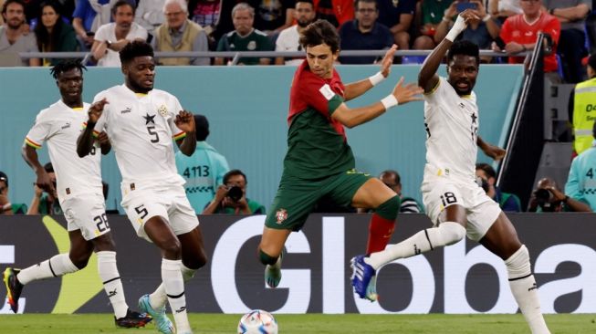 Penyerang Timnas Portugal #11 Joao Felix (kedua dari kanan) berebut bola dengan gelandang Ghana #05 Thomas Partey (kedua dari kiri) dan bek Ghana #18 Daniel Amartey (kanan) selama matchday pertama Grup H Piala Dunia 2022 antara Portugal vs Ghana di Stadion 974 di Doha pada 24 November 2022.Khaled DESOUKI / AFP.