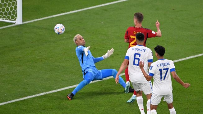 Penyerang Spanyol Dani Olmo (Tengah) mencetak gol melewati penjaga gawang Kosta Rika Keylor Navas (Kiri) selama pertandingan sepak bola Grup E Piala Dunia 2022 antara Spanyol dan Kosta Rika di Stadion Al-Thumama di Doha, Qatar, Rabu (23/11/2022). [Kirill KUDRYAVTSEV / AFP]
