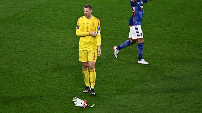 Kiper Jerman Manuel Neuer (Kiri) tertunduk lesu usai negaranya kalah dalam pertandingan sepak bola Grup E Piala Dunia 2022 antara Jerman dan Jepang di Stadion Internasional Khalifa di Doha, Qatar, Rabu (23/11/2022). [Anne-Christine POUJOULAT / AFP]