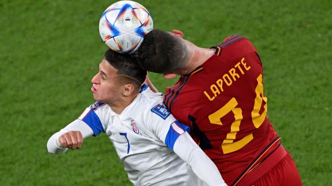 Penyerang Kosta Rika Anthony Contreras (Kiri) bertarung memperebutkan bola dengan bek Spanyol Aymeric Laporte selama pertandingan sepak bola Grup E Piala Dunia 2022 antara Spanyol dan Kosta Rika di Stadion Al-Thumama di Doha, Qatar, Rabu (23/11/2022). [Kirill KUDRYAVTSEV / AFP]