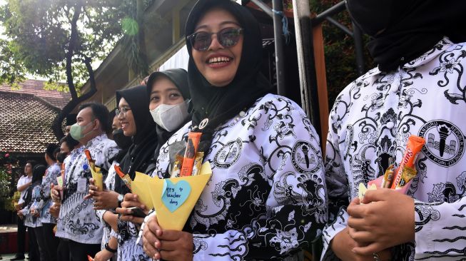 Para guru menerima cinderamata dari siswa saat Upacara Peringatan Hari Guru Nasional di SMK Bunda Kandung, Jakarta, Jumat (25/11/2022). [ANTARA FOTO/Indrianto Eko Suwarso]