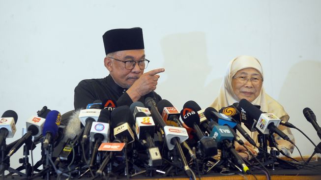 Perdana Menteri Malaysia Anwar Ibrahim (kiri) bersama Ibu Negara Dato' Seri Wan Azizah Wan Ismail ketika memberikan keterangan pers usai menghadap Raja Malaysia, Yang di-Pertuan Agong Al-Sultan Abdullah Ri'ayatuddin Al Mustafa Billah Shah di Sungai Long Golf & Country Resort, Kajang, Selangor, Malaysia, Kamis (24/11/2022).  ANTARA FOTO/Rafiuddin Abdul Rahman