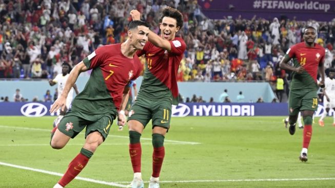 Penyerang Timnas Portugal #07 Cristiano Ronaldo (Kiri) melakukan selebrasi setelah mencetak gol pertama timnya dari tembakan penalti selama matchday pertama Grup H Piala Dunia 2022 antara Portugal vs Ghana di Stadion 974 di Doha pada 24 November 2022.PATRICIA DE MELO MOREIRA / AFP.