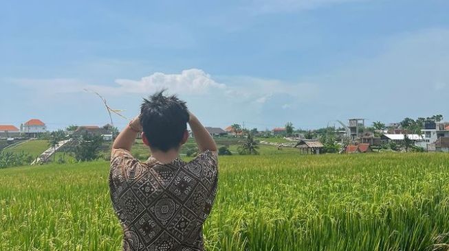 Rich Brian berfoto di pinggir sawah (Instagram/@brianimanuel)