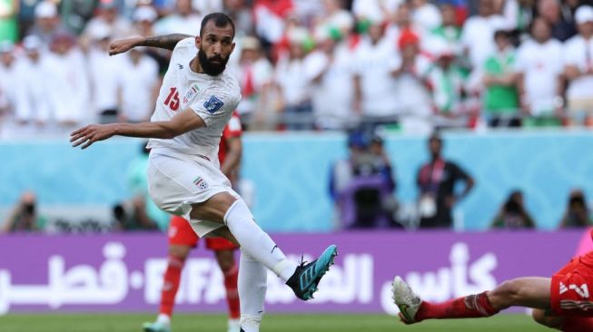 Gelandang Timnas Iran, Rouzbeh Cheshmi melakukan tendangan yang berbuah gol pada laga kontra Wales di Stadion Ahmed bin Ali, Qatar, Jumat (25/11/2022) petang WIB. [FADEL SENNA / AFP]