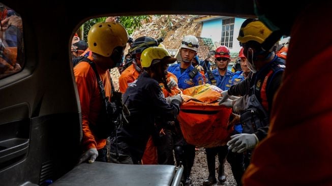 Tim SAR gabungan menggotong jenazah korban tertimbun longsor ke dalam mobil ambulans di Kampung Cijedil, Cugenang, Kabupaten Cianjur, Jawa Barat, Sabtu (26/11/2022). [ANTARA FOTO/Raisan Al Farisi/nym].