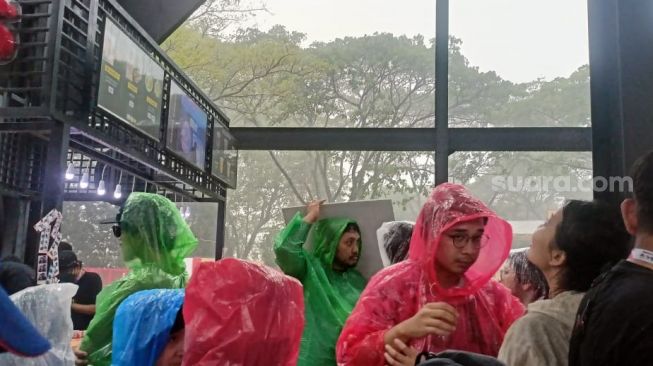 Suasana di venue Soundrenaline saat diguyur hujan, Eco Park Ancol, Jakarta Utara pada Sabtu (26/11/2022) [Suara.com/Rena Pangesti]