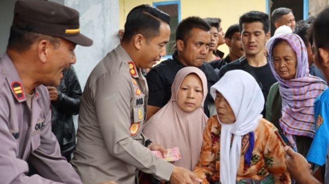 Kapolres Cianjur Doni Hermawan saat membantu ibu yang mengungsi akibat gempa di posko pengungsian Polres Cianjur.(ANTARA/Ahmad Fikri)
