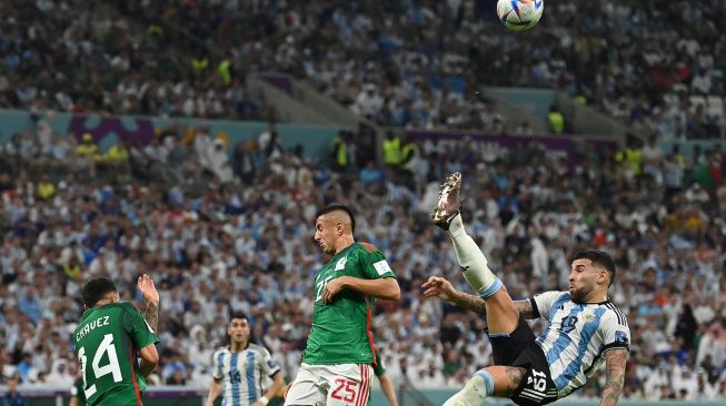 Bek Argentina Nicolas Otamendi (kanan) melakukan tendangan salto saat pertandingan sepak bola Grup C Piala Dunia 2022 antara Argentina dan Meksiko di Stadion Lusail di Lusail, Qatar, Sabtu (26/11/2022). [Glyn KIRK / AFP]