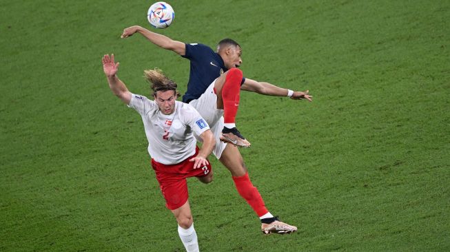 Bek Denmark Joachim Andersen berebut bola dengan penyerang Prancis Kylian Mbappe selama pertandingan sepak bola Grup D Piala Dunia 2022 antara Prancis dan Denmark di Stadion 974 di Doha, Qatar, Sabtu (26/11/2022). [Anne-Christine POUJOULAT / AFP]