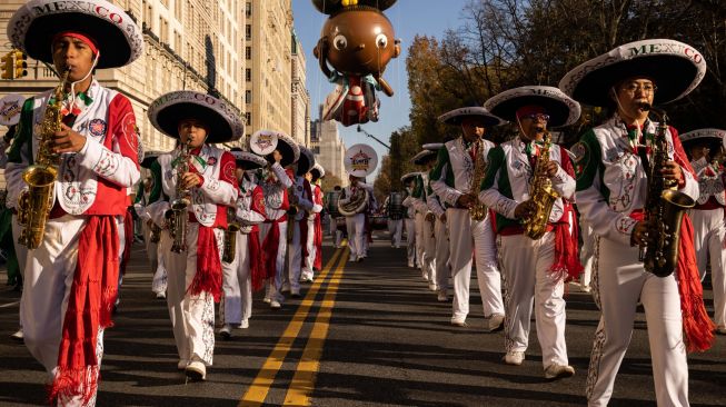 Marching band Meksiko mengiringi balon Ada twist selama Parade Hari Thanksgiving Macy Tahunan ke-96 di New York City, Amerika Serikat, Kamis (24/11/2022). [Yuki IWAMURA / AFP]