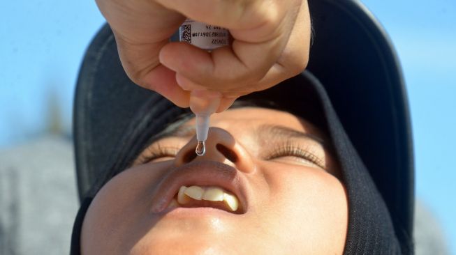 Petugas kondisi tubuh memberikan imunisasi polio terhadap murid sekolah pada waktu berlangsung vaksinasi massal pada Pusat Kota Pidie, Kota Pidie, Aceh, Hari Senin (28/11/2022). [ANTARA FOTO/Ampelsa/hp]