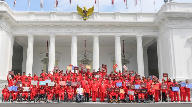 Presiden Joko Widodo (tengah) didampingi Mensesneg Pratikno dan Menpora Zainudin Amali berfoto bersama atlet dan ofisial setelah menyerahkan bonus kepada atlet ASEAN Para Games 2022 di halaman Istana Merdeka, Jakarta, Senin (28/11/2022). [ANTARA FOTO/Hafidz Mubarak A/hp]