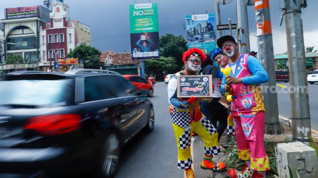 Anggota badut Depok menggalang dana untuk korban gempa bumi Cianjur di Margonda, Depok, Jawa Barat, Senin (28/11/2022). [Suara.com/Alfian Winanto]