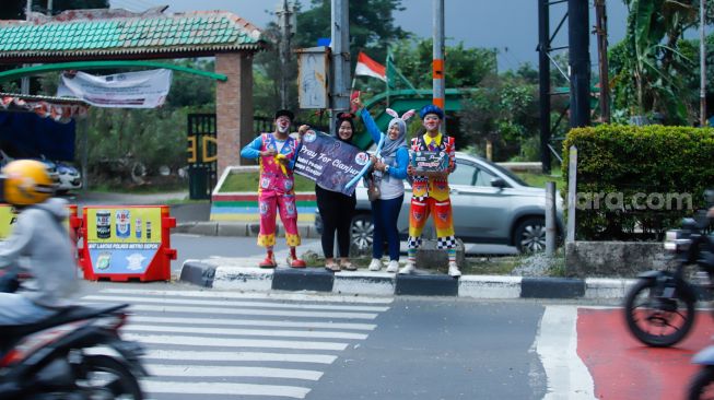 Anggota badut Depok menggalang dana untuk korban gempa bumi Cianjur di Margonda, Depok, Jawa Barat, Senin (28/11/2022). [Suara.com/Alfian Winanto]