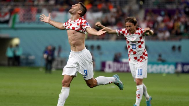 Penyerang Kroasia Andrej Kramaric merayakan golnya di samping gelandang Kroasia Luka Modric saat pertandingan sepak bola Grup F Piala Dunia 2022 antara Kroasia dan Kanada di Stadion Internasional Khalifa di Doha, Qatar, Minggu (27/11/2022). [ADRIAN DENNIS / AFP]