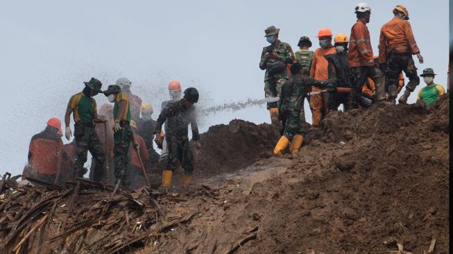 Personel TNI mengguyur pakaian dengan air usai mengangkat korban yang tertimbun longsor akibat gempa di Kampung Cijedil, Cugenang, Kabupaten Cianjur, Jawa Barat, Minggu (27/11/2022). [ANTARA FOTO/Wahyu Putro A/aww]