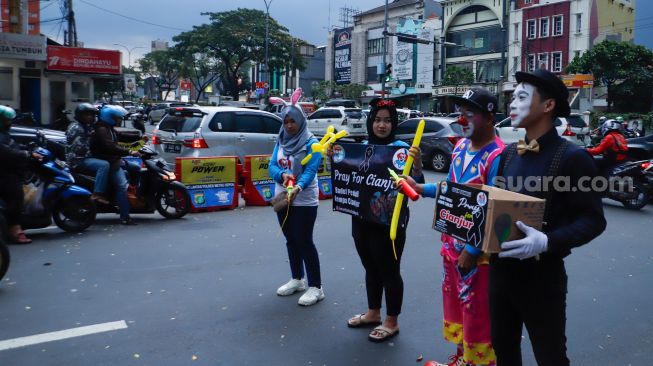 Anggota badut Depok menggalang dana untuk korban gempa bumi Cianjur di Margonda, Depok, Jawa Barat, Senin (28/11/2022). [Suara.com/Alfian Winanto]