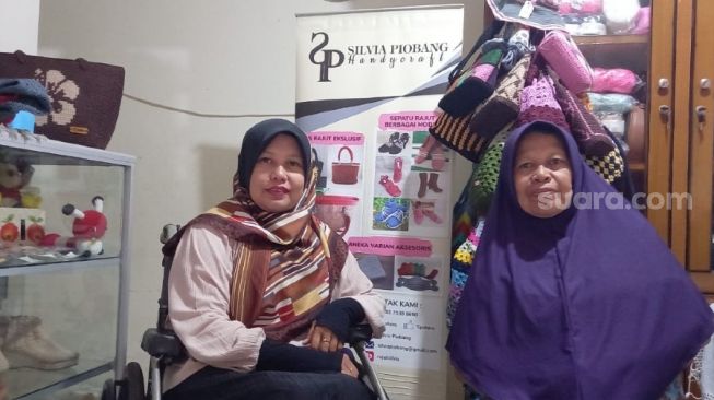 Silvia Piobang bersama Amaknya (ibu) saat bercerita panjang tentang perjalanannya bangkit dari rasa putus asa di rumahnya, di Kota Padang. [Suara.com/Riki Chandra]