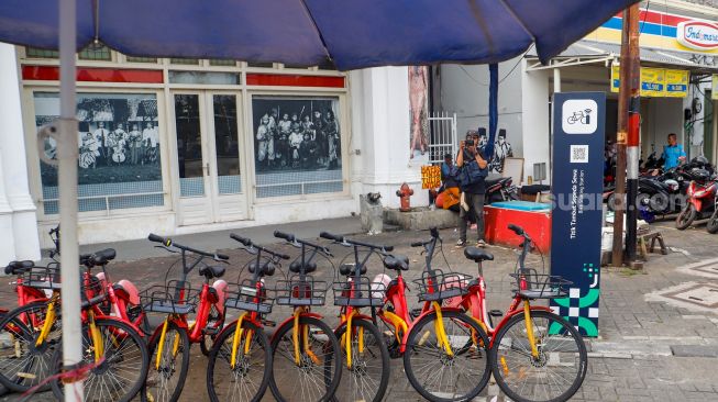 Warga melintas melihat sepeda sewa yang terparkir di Pasar Baru, Jakarta Pusat, Rabu (30/11/2022). [Suara.com/Alfian Winanto]