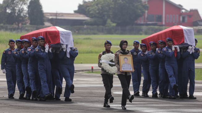 Sejumlah prajurit Polri membawa peti jenazah CoPilot helikopter milik Polri NBO-105 Briptu M Lasminto dan peti jenazah mekanik helikopter Bripda Khairul Anam saat upacara penyerahan jenazah di Lapangan Terbang Polisi Udara, Pondok Cabe, Tangerang Selatan, Banten, Rabu (30/11/2022). [ANTARA FOTO/Fauzan/YU]