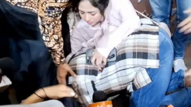 Winarsih bersujud di kaki ibunda Dewi Perssik. (YouTube/ insertlive)