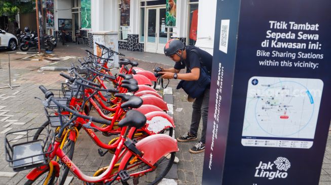 Warga melintas melihat sepeda sewa yang terparkir di Pasar Baru, Jakarta Pusat, Rabu (30/11/2022). [Suara.com/Alfian Winanto]