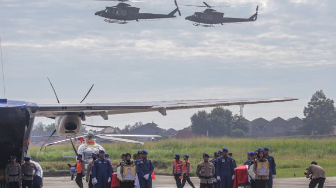 Sejumlah prajurit Polri berdiri di antara peti jenazah CoPilot helikopter milik Polri NBO-105 Briptu M Lasminto dan peti jenazah mekanik helikopter Bripda Khairul Anam saat upacara penyerahan jenazah di Lapangan Terbang Polisi Udara, Pondok Cabe, Tangerang Selatan, Banten, Rabu (30/11/2022). [ANTARA FOTO/Fauzan/YU]