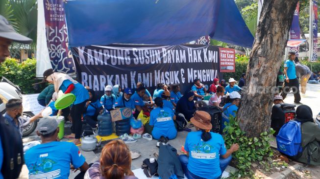 Warga Kampung Bayam berada di dalam tenda saat menggelar aksi unjuk rasa di depan Balai Kota Jakarta, Kamis (1/12/2022). [Suara.com/Alfian Winanto]