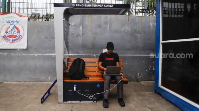 Warga mengisi daya gawainya di stasiun pengisi daya listrik bertenaga surya di kawasan Dukuh Atas, Jakarta Pusat, Senin (14/11/2022). [Suara.com/Alfian Winanto]