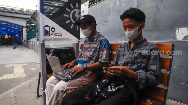 Warga mengisi daya gawainya di stasiun pengisi daya listrik bertenaga surya di kawasan Dukuh Atas, Jakarta Pusat, Senin (14/11/2022). [Suara.com/Alfian Winanto]