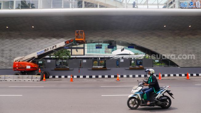 Sejumlah kendaraan melintas di dekat proyek revitalisasi Halte Tosari di Jalan Jenderal Sudirman, Jakarta Pusat, Jumat (2/12/2022). [Suara.com/Alfian Winanto]