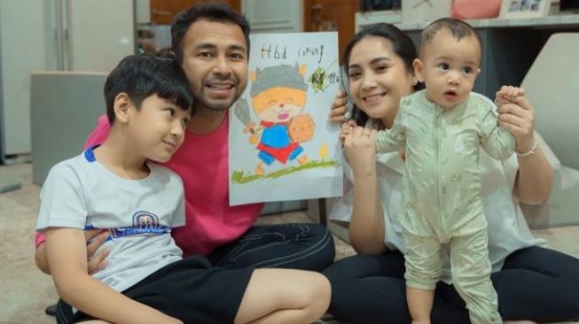 Rafathar memberikan kado lukisan yang ia buat sendiri untuk sang adik, Cipung yang berulang tahun pertama. [RANS Entertainment]