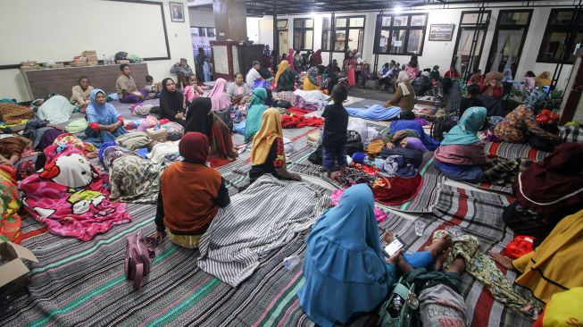 Sejumlah warga terdampak abu vulkanik dari awan panas guguran (APG) Gunung Semeru mengungsi di Kantor Kecamatan Candipuro, Lumajang, Jawa Timur, Minggu (4/12/2022).  ANTARA FOTO/Umarul Faruq