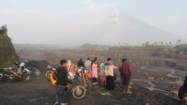 Sejumlah warga melihat jalur aliran lahar dan Awan Panas Guguran (APG) Gunung Semeru di kawasan Besuk Koboan, Pronojiwo, Lumajang, Jawa Timur, Senin (5/12/2022). [ANTARA FOTO/Ari Bowo Sucipto].