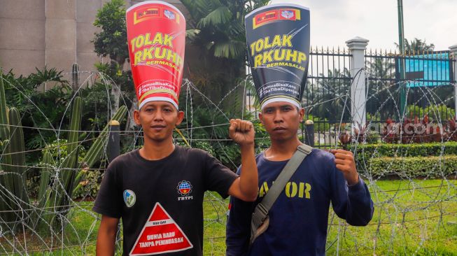 Massa saat menggelar aksi unjuk rasa menolak pengesahan RKUHP di depan Gedung DPR RI, Senayan, Jakarta Pusat, Senin (5/12/2022). [Suara.com/Alfian Winanto]