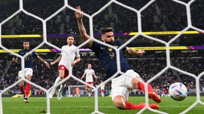 Penyerang Prancis Olivier Giroud menembak tetapi gagal mencetak gol saat pertandingan sepak bola babak 16 besar Piala Dunia 2022 antara Prancis dan Polandia di Stadion Al-Thumama, Doha, Qatar, Minggu (4/12/2022). [Kirill KUDRYAVTSEV / AFP]
