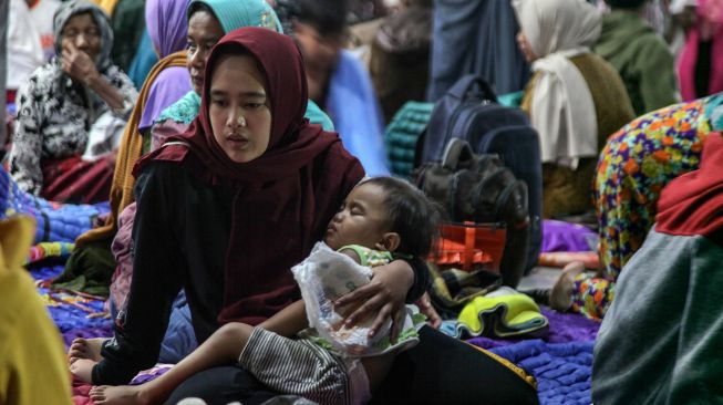 Sejumlah warga terdampak abu vulkanik dari awan panas guguran (APG) Gunung Semeru mengungsi di Kantor Kecamatan Candipuro, Lumajang, Jawa Timur, Minggu (4/12/2022).  ANTARA FOTO/Umarul Faruq
