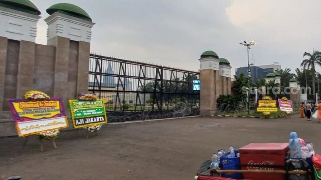 Koalisi Masyarakat Sipil meninggalkan karangan bunga duka cita di depan Gedung DPR RI, Jakarta Pusat, usai aksi demonstrasi menolak pengesahan pasal bermasalah. (Suara.com/Yaumal)