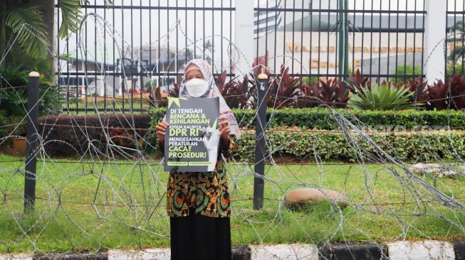 Massa saat menggelar aksi unjuk rasa menolak pengesahan KUHP di depan Gedung DPR RI, Senayan, Jakarta Pusat, Selasa (6/12/2022). [Suara.com/Alfian Winanto]