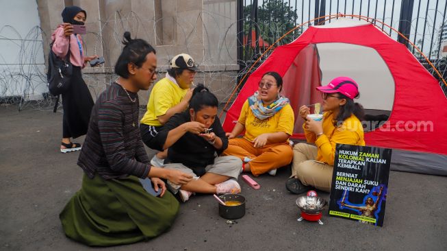 Massa saat menggelar aksi unjuk rasa menolak pengesahan KUHP di depan Gedung DPR RI, Senayan, Jakarta Pusat, Selasa (6/12/2022). [Suara.com/Alfian Winanto]