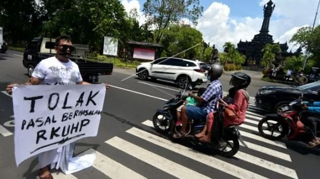 Jurnalis di Kota Denpasar melakukan aksi jalan mundur. Sebagai bentuk kritik terhadap pasal-pasal bermasalah dalam RKUHP, Senin 5 Desember 2022 [SuaraBali.id/Antara]