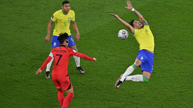 Gelandang Brazil Lucas Paqueta berebut bola dengan gelandang Korea Selatan Son Heung-min saat pertandingan sepak bola babak 16 besar Piala Dunia 2022 antara Brazil dan Korea Selatan di Stadion 974 di Doha, Qatar, Senin (5/12/2022). [Glyn KIRK / AFP]