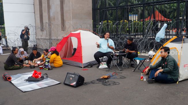 Massa saat menggelar aksi unjuk rasa menolak pengesahan KUHP di depan Gedung DPR RI, Senayan, Jakarta Pusat, Selasa (6/12/2022). [Suara.com/Alfian Winanto]